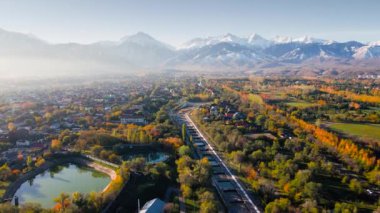 Büyük Almaty Nehri 'nin hava aracı manzarası ve arka planda kar dağları manzaralı evler Kazakistan' ın Almaty şehrinde.