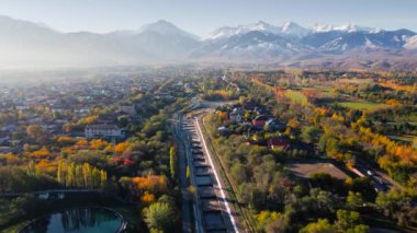 Büyük Almaty Nehri 'nin hava aracı manzarası ve arka planda kar dağları manzaralı evler Kazakistan' ın Almaty şehrinde.