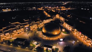 Altyn Samuryk 'un Türkistan' da gece vakti altın yumurta şeklinde uçan tiyatrosunun insansız hava aracı görüntüsü. Güney Kazakistan 'da modern doğu mimarisi