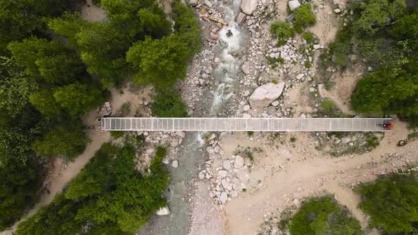 Aerial View Man Riding Electric Bike Crossing River Bridge Mountains — Stock Video