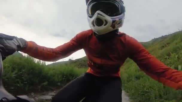 緑の山林のトレイルで電動バイクに乗ってフルフェイスヘルメットでマウンテンバイカーの肖像画 サイクリストのバービューの背後にあるPov — ストック動画