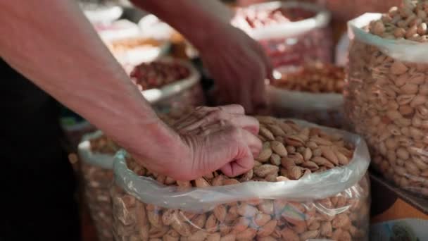 Mann Verkauft Frische Mandelernte Und Trockenfrüchte Tüten Auf Lokalem Lebensmittelmarkt — Stockvideo