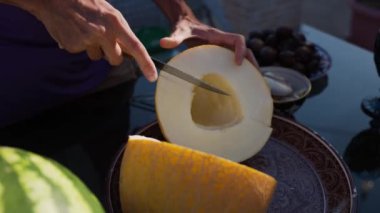 Özbekistan, Bukhara 'da restoranda insan olgun sarı Özbek kavununu bıçakla parçalara ayırdı