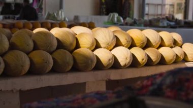 Özbekistan 'ın Buhara kentindeki pazarda olgun sarı Özbek kavunu yığınları