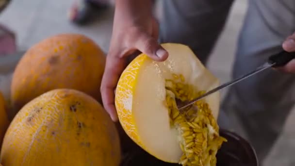 Mann Schneidet Reife Gelbe Usbekische Melone Mit Messer Auf Marktbasar — Stockvideo