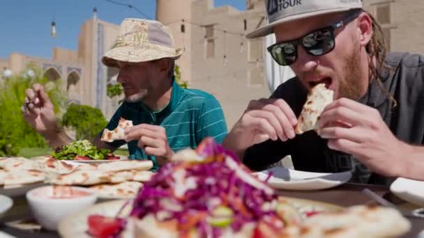 Két Kalapos Turista Üzbég Ételeket Eszik Samsa Vagy Sambousak Nemzeti — Stock videók