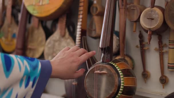 우즈베키스탄의 부하라 시장에서 손으로 악기를 만지는 — 비디오