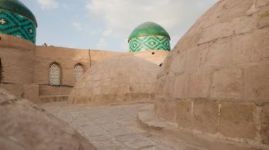 Özbekistan 'ın Itchan Kala antik kenti Khiva' daki şehir duvarında mavi süslemeli ve şapkalı genç kadın portresi.