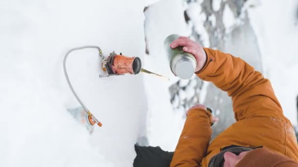 人間の垂直ビデオは ガスストーブの上の山の銅の凍結からコーヒーを準備します 飲料を作る スローモーションでサーモストストから熱湯を注ぐ — ストック動画