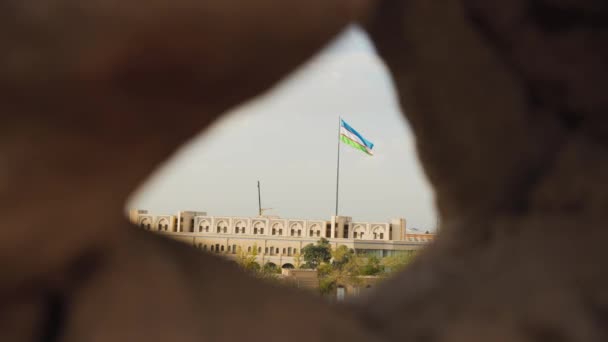 乌兹别克斯坦Khiva古城墙与蓝天相映成趣的乌兹别克国旗 — 图库视频影像