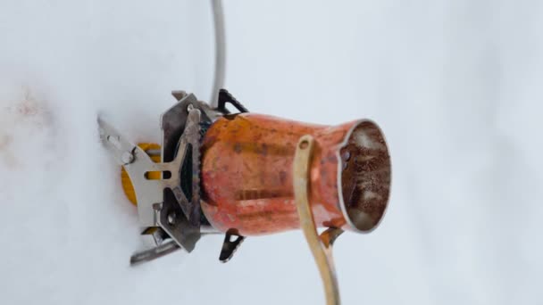 人間の垂直ビデオは ガスストーブで沸騰する山で銅の凍結からコーヒーを準備します Ibrikから遅い動きに飲料を作る — ストック動画