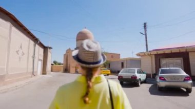 Sarı gömlekli turist kadın Gur Emir Anıtmezarında Semerkant, Özbekistan 'da mavi gökyüzüne karşı yürüyor