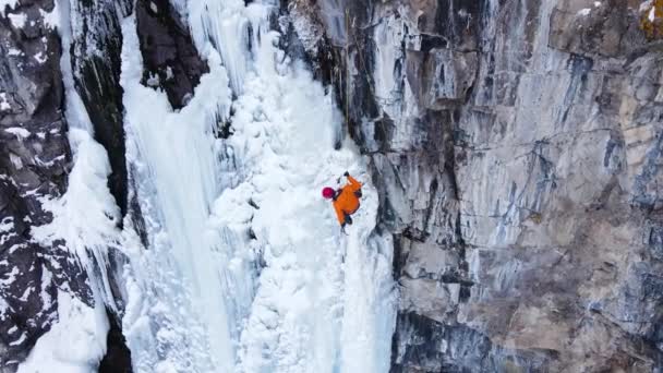 Воздушный Беспилотник Вид Спортсмена Ледолазание Большой Замерзший Водопад Горах Вблизи — стоковое видео