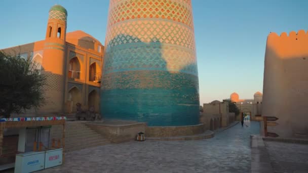 ブルー カルタ マイナー ミナレットと古いマドラサのパノラマショット ウズベキスタンのイチャンカラ古代都市キヴァ — ストック動画