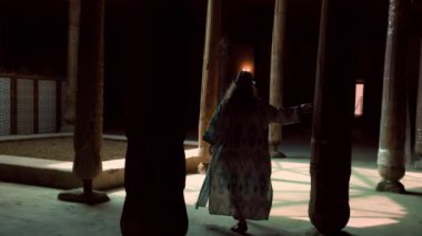 Juma Camii, Khiva, Özbekistan 'da oymalarla süslenmiş ahşap sütunlar içindeki etnik kadın..