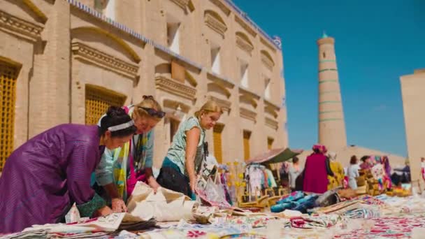 Khiva Uzbekistan 2023年9月25日 女游客在旧城广场的街头市场购买传统纪念品和地毯 — 图库视频影像