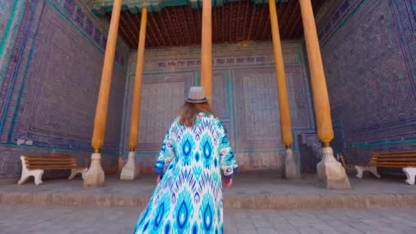 在汉宫塔什 考利的Arzkhana院子里 身穿民族服装 头戴蓝色饰物的年轻女子在散步 乌兹别克斯坦Khiva的Itchan Kala古城 — 图库视频影像