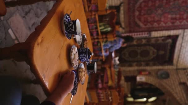 ブハラの東洋の伝統茶屋でコーヒーを飲む女性の垂直ビデオ — ストック動画