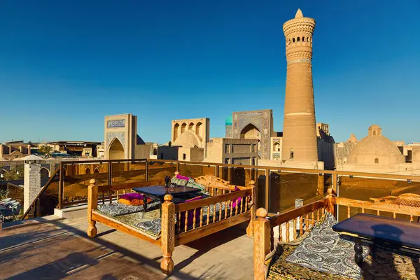 乌兹别克斯坦Kalyan Minaret和Madrasah附近Bukhara设有顶层餐桌的顶层餐厅 — 图库照片