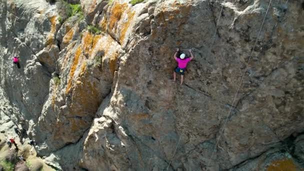 在哈萨克斯坦南部伊利河上 穿着粉色运动衫的男子运动员爬上岩石的空中照片 — 图库视频影像