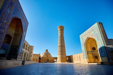 Özbekistan, Buhara 'da gün batımında kültür meydanı ve Kalyan minare camii medresesi manzarası