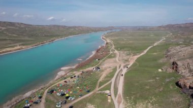 Ili nehri yakınlarındaki çadır ve Kazakistan 'daki mavi bulutlu gökyüzünde bahar bozkırlarının insansız hava görüntüsü.