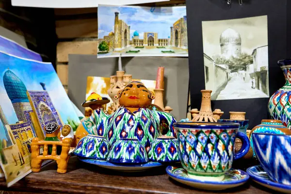 乌兹别克斯坦 丝绸之路 撒马尔罕纪念品商店装饰彩陶壶和装有传统装饰品的杯子 免版税图库照片