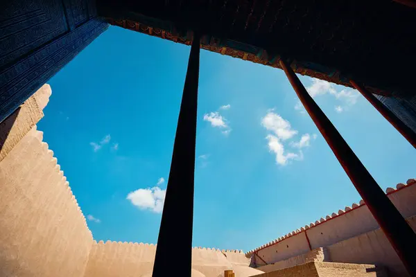 ウズベキスタンの古代都市キヴァのタシュ ハウリにある木の柱と青い空を備えた夏の宮殿の外観 ストックフォト