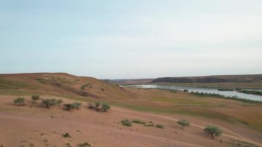 Ili nehri yakınlarındaki çadır ve Kazakistan 'daki mavi bulutlu gökyüzünde bahar bozkırlarının insansız hava görüntüsü.