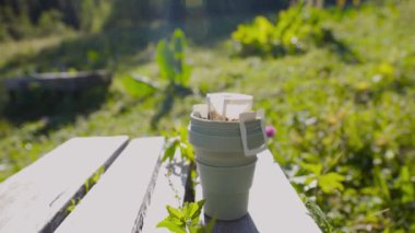 Fincanda kahve torbası. Bahçe masasındaki termostan gelen sıcak suyla demlenen içecek süreci.