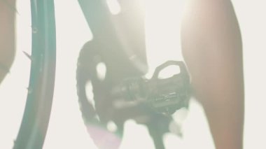 Spor ayakkabılı bir sporcu sabahları bisiklet üzerinde antrenman yapar. Pedal çevirme bacak triatlon eğitim konseptine yakın çekim.