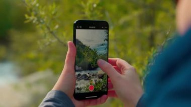 Genç kadın gezgin akıllı telefon kamerasıyla inanılmaz doğa dağ manzarası sosyal medya için video çekiyor. Seyahat tutkusu turizm konsepti.