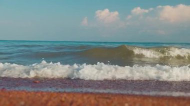 Gün batımında Issyk-kul Gölü 'nde küçük dalgalar olan boş kumlu bir sahil. Yazın Kırgızistan 'daki Kaji Sai köyü.