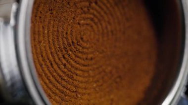 El baristasının el yapımı espresso yaparken çekilmiş dikey bir video. El yapımı kahve, kahve makinesiyle öğütülmüş.