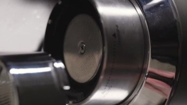 Barista 'nın dikey videosu profesyonel espresso makinesindeki filtreyi alttan kapat.