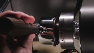 Barista 'nın dikey videosu profesyonel espresso makinesindeki filtreyi alttan kapat.