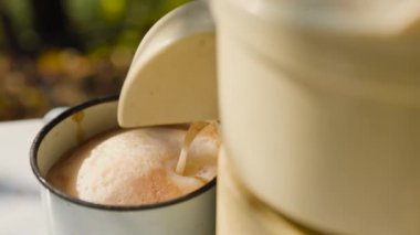 Bahçesindeki masada duran meyve suyu köpüğünden tatlı köpüklü meyve suyu akıyor. Doğal elma suyu yapmak için yakın çekim..