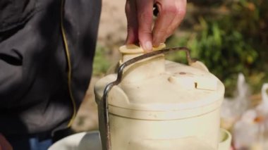 Erkek elleri bahçesindeki masada meyve sıkacağının içine elma koyar. Doğal elma suyu yapmak için yakın çekim..