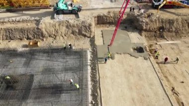 Kırmızı vinç ve işçi vakfından dökülen Beton mikserin havadan drone görüntüsü..