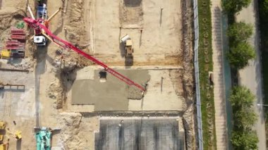 Kırmızı vinç ve işçi vakfından dökülen Beton mikserin havadan drone görüntüsü..