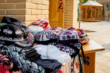 Etnik renkli geleneksel şapka tubiteykası ve Özbekistan, Orta Asya 'da Khiva' da sokak pazarında geleneksel Özbek süsü bulunan çantalar