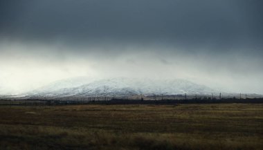 Kar dağları vadisinin güzel manzarası ve karanlık fırtına gökyüzü ve Taraz şehrinde yağmur, Kazakistan