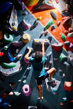 Spor meraklısı, kapalı spor salonunda dik duvara tırmanıyor. Ekstrem spor ve kaya konsepti