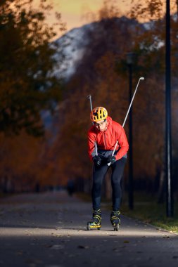 Patencilerin üzerinde kasklı ve kırmızı ceketli bir erkek sporcu antrenmanı. Kayak dağı disiplini için İskandinav kayak anlayışı