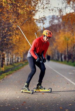Patencilerin üzerinde kasklı ve kırmızı ceketli bir erkek sporcu antrenmanı. Kayak dağı disiplini için İskandinav kayak anlayışı