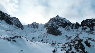 Dağ aralığının hava drone görüntüsü. Bakire beyaz karla kaplı. Kazakistan 'ın Almaty şehrindeki Tien Shan Dağı