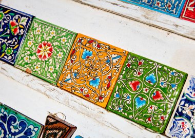 Özbekistan 'ın Khiva kentindeki sokak pazarında sarı ve yeşil boyalı seramik fayanslar mıknatıs eşyası