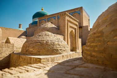 Özbekistan 'ın Khiva kentindeki Kalta Minor minaresi ve antik kent duvarının gün batımı manzarası