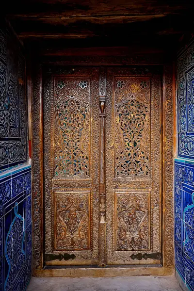 Özbekistan 'ın başkenti Khiva' nın göbeğindeki eski saraydaki güzel medresenin eski ahşap kapısı. Orta Asya 'da turizm ve seyahat kavramı
