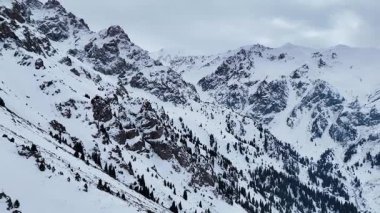 Dağ aralığının hava drone görüntüsü. Bakire beyaz karla kaplı. Kazakistan 'ın Almaty şehrindeki Tien Shan Dağı